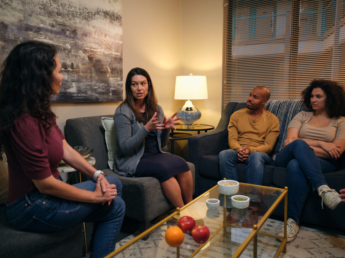 A small group talking in a warm, home-like living room