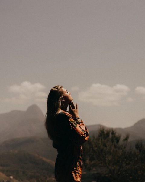 woman in black jacket standing on green grass field during daytime