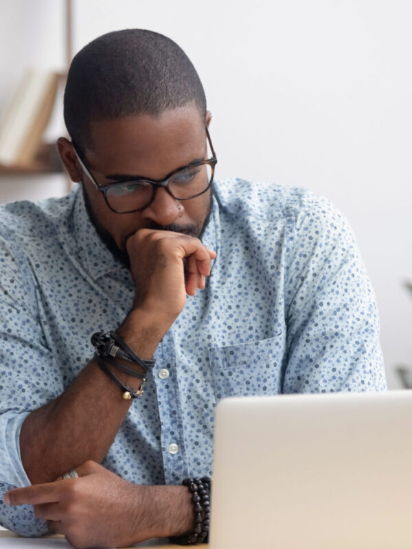 Head,Shot,Serious,Puzzled,African,American,Businessman,Looking,At,Laptop